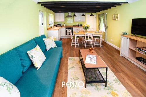 Burton Joyce的住宿－Cosy 1-bed Cottage in Stoke Bardolph, Nottingham by Renzo, Stunning Countryside Location!，客厅配有蓝色的沙发和桌子