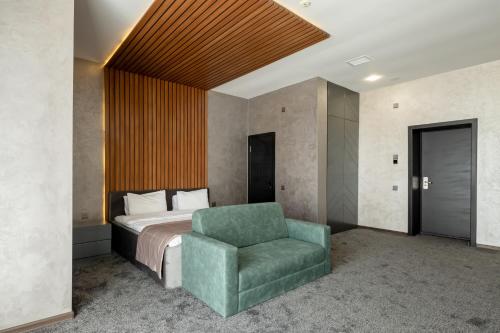 sypialnia z łóżkiem i zielonym krzesłem w obiekcie Mona Hotel and Cottages w mieście Sütǝmurdov