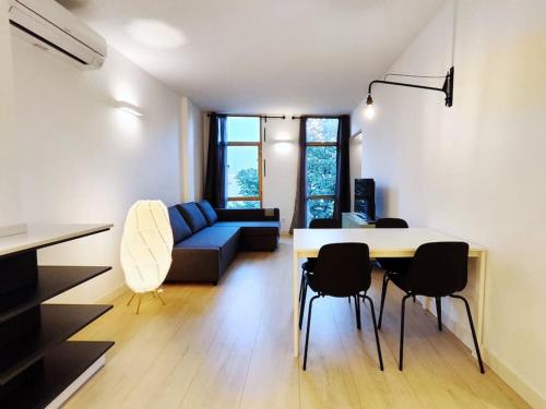 ein Wohnzimmer mit einem Sofa, einem Tisch und Stühlen in der Unterkunft Moderno Apartamento en Terrassa Centro in Terrassa