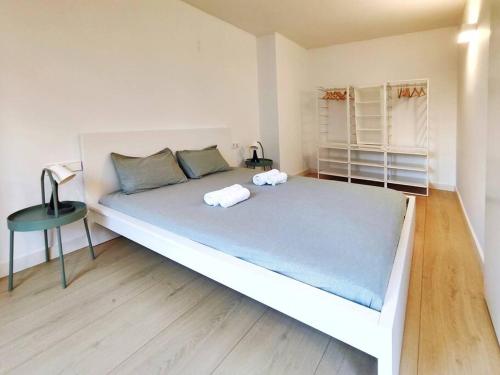 ein großes weißes Bett in einem Zimmer mit einem Tisch in der Unterkunft Moderno Apartamento en Terrassa Centro in Terrassa