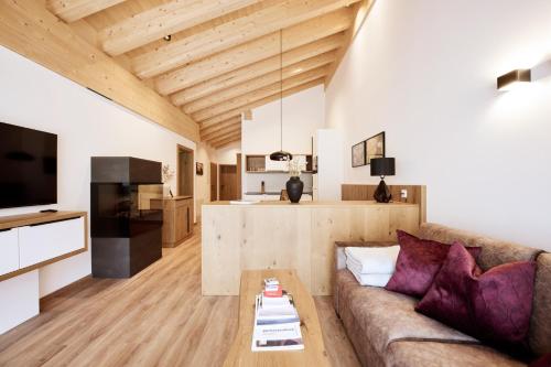 uma sala de estar com um sofá e uma mesa em Alpenstolz Damüls Haus 2 - Stilvoll urlauben in den Bergen em Damüls