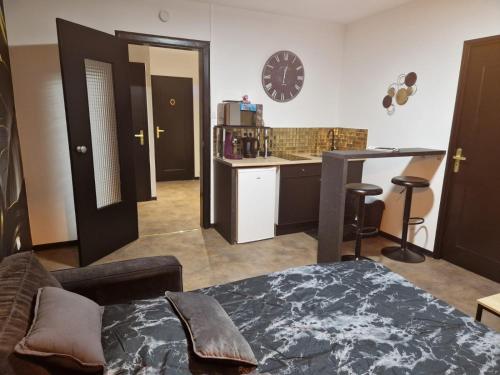 une chambre avec une table et une cuisine avec une horloge dans l'établissement Appartement spacieux MULHOUSE, à Mulhouse