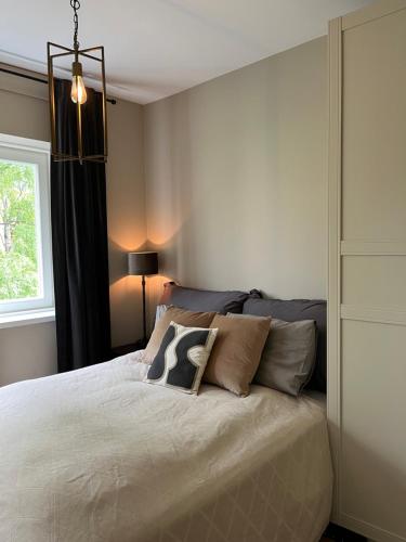 a bedroom with a bed with pillows on it at Stylish 3-room apartment with balcony and free parking in Oslo