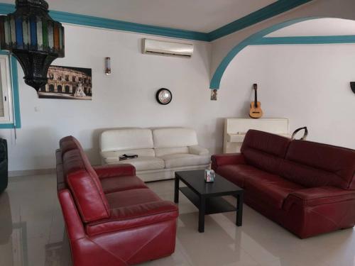 a living room with a red couch and a table at RESIDENCE BELIER 