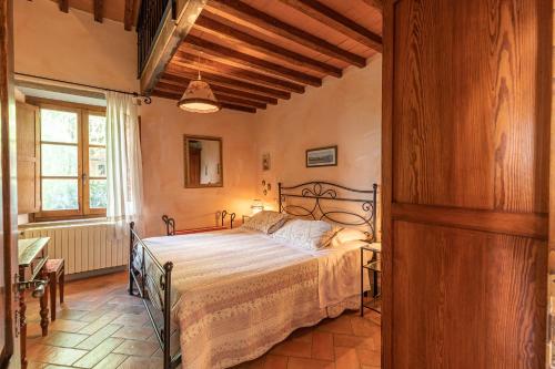 ein Schlafzimmer mit einem Bett in einem Zimmer in der Unterkunft Borgo Dolci Colline Resort Granaio in Castiglion Fiorentino