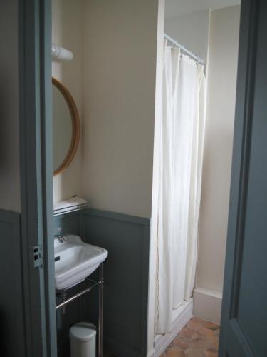 ein Bad mit einem Waschbecken und einem Duschvorhang in der Unterkunft La suite Armel proposé par escaleasaintbriac in Saint-Briac-sur-Mer