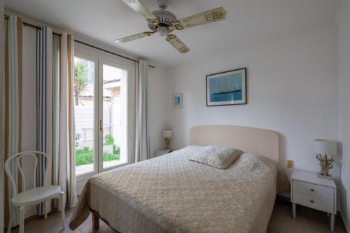 une chambre avec un lit et un ventilateur de plafond dans l'établissement Maison élégante à 100 m de la mer, à Fréjus