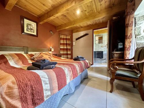 1 dormitorio con 1 cama y 1 silla en La myrtilleraie, en Péreyres