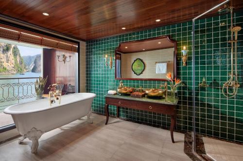 a bathroom with a tub and a green tiled wall at Indochine Premium Halong Bay Powered by Aston in Ha Long