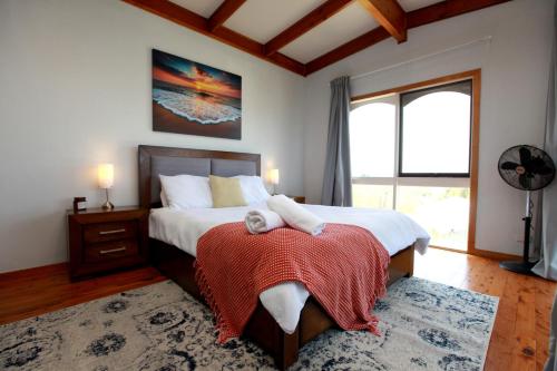 a bedroom with a bed and a large window at Tequila Sunset Beachfront Family Holiday Home, Bass Coast in Grantville