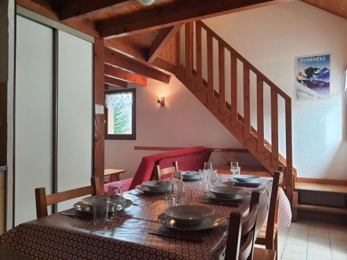 une salle à manger avec une table et un escalier dans l'établissement Chalet cosy 4/5 personnes avec jardins, parking, proche télécabine, navette gratuite - FR-1-401-228, à Cauterets