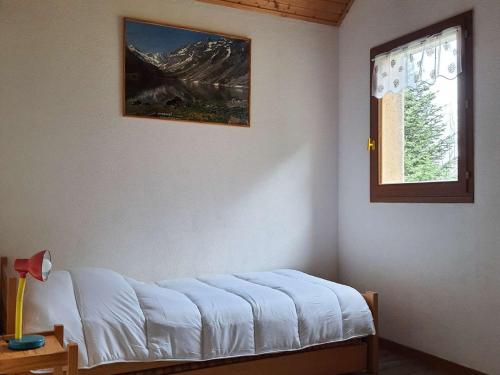 Cette chambre dispose d'un lit et d'une fenêtre. dans l'établissement Chalet cosy 4/5 personnes avec jardins, parking, proche télécabine, navette gratuite - FR-1-401-228, à Cauterets