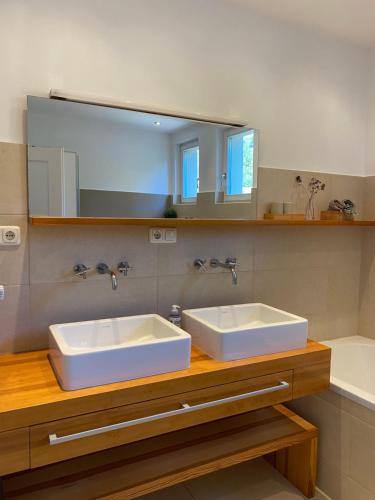 ein Badezimmer mit zwei weißen Waschbecken und einem Spiegel in der Unterkunft Exklusives Ferienhaus in Top Lage: Der Johannishof in Würzburg