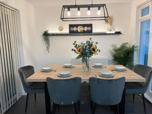 a dining room table with chairs and a vase of flowers at Large 4 Bed, Central Oxford, Games Area, On-Site Parking in Oxford