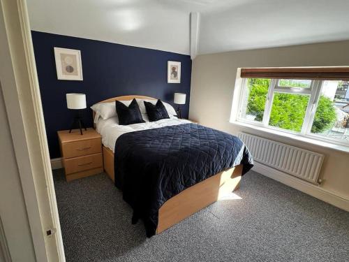 a bedroom with a bed with a blue wall at Large 4 Bed, Central Oxford, Games Area, On-Site Parking in Oxford