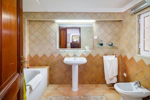 a bathroom with a sink and a toilet and a mirror at 7 Bedroom Private Villa Tenazinha II, with pool in Albufeira