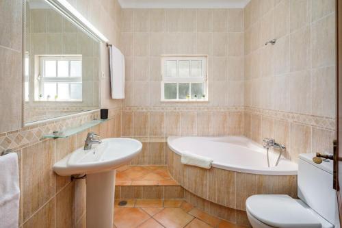 a bathroom with a tub and a toilet and a sink at 7 Bedroom Private Villa Tenazinha II, with pool in Albufeira