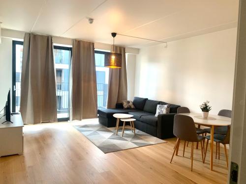 sala de estar con sofá y mesa en Demims Apartments Lillestrøm - Modern & Super Central - 10mins from Oslo S, en Lillestrøm