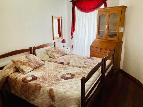 a bedroom with two beds and a dresser at Alfazema in São Sebastião