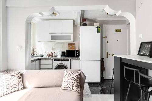 ein weißes Wohnzimmer mit einem Sofa und einer Küche in der Unterkunft Practical and Cozy Flat Near Taksim İstikal in Istanbul