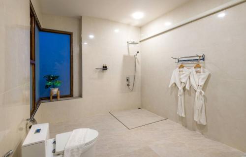 a white bathroom with a toilet and a shower at Phi Phi Mountain Beach Resort SHA Certified in Phi Phi Don