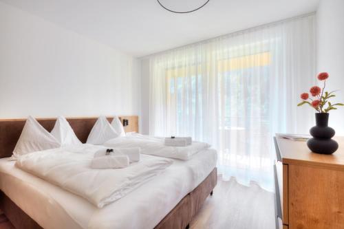 a large bed in a room with a large window at Alpenstolz Damüls Haus 3 - Stilvoll urlauben in den Bergen in Damuls