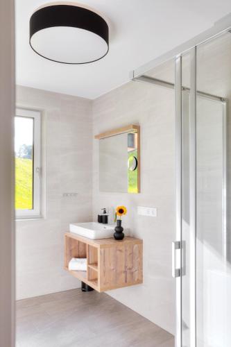 a bathroom with a sink and a mirror at Alpenstolz Damüls Haus 3 - Stilvoll urlauben in den Bergen in Damuls