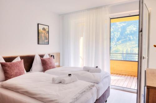 two beds in a bedroom with a balcony at Alpenstolz Damüls Haus 3 - Stilvoll urlauben in den Bergen in Damuls