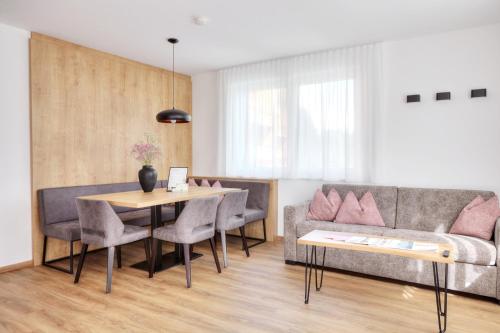 a living room with a couch and a table at Alpenstolz Damüls Haus 3 - Stilvoll urlauben in den Bergen in Damuls