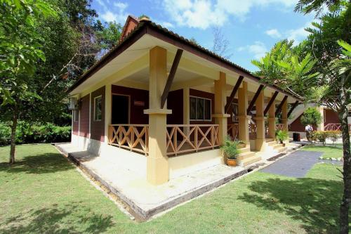 a small house with a porch and a grass yard at Rompin Beach Resorts in Kuala Rompin