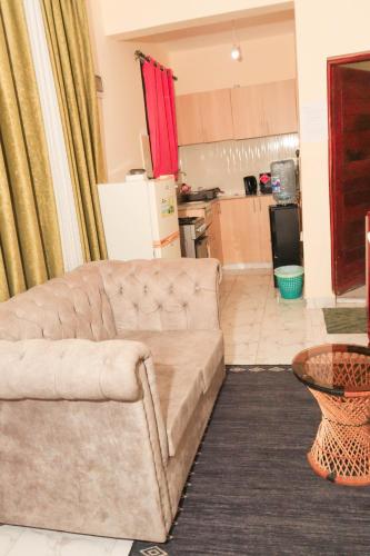 ein Wohnzimmer mit einem Sofa und einer Küche in der Unterkunft AMELIA BNBS in Mtwapa