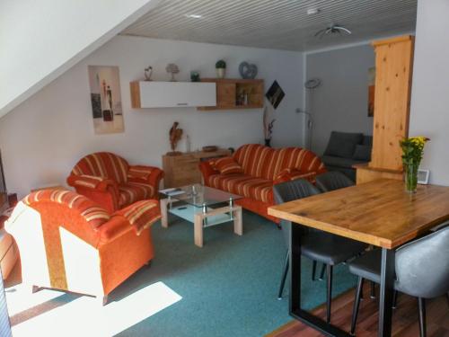 ハーネンクレー・ボックスヴィーゼにあるApartment Waldoase by Interhomeのリビングルーム(オレンジの椅子、テーブル付)