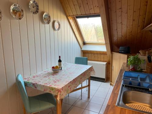 a kitchen with a table with a bottle of wine at Apartment Old Hüsung - MUZ320 by Interhome in Mirow