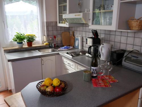 a kitchen with a bowl of fruit and a bottle of wine at Apartment Am Pälitzsee-2 by Interhome in Strasen