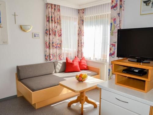 a living room with a couch and a flat screen tv at Apartment Niederhof by Interhome in Kappl