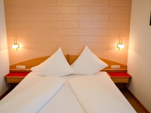 a bed with white sheets and two pillows on it at Apartment Niederhof by Interhome in Kappl