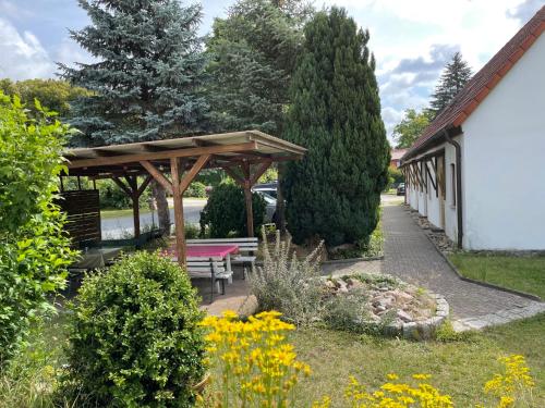 a picnic shelter with a bench in a garden at Apartment Am Pälitzsee-1 by Interhome in Strasen