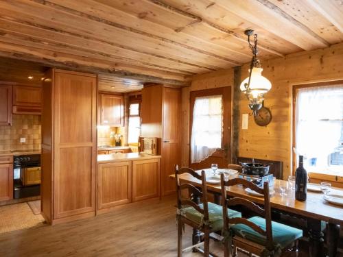 a kitchen with a wooden ceiling and a table with chairs at Chalet La Pive by Interhome in Verbier