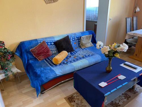 ein blaues Sofa mit Kissen und einen Tisch im Wohnzimmer in der Unterkunft Apartment Old Hüsung - MUZ321 by Interhome in Mirow