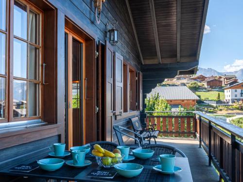 una mesa con tazones de fruta en el balcón en Chalet Mustela by Interhome, en Nendaz