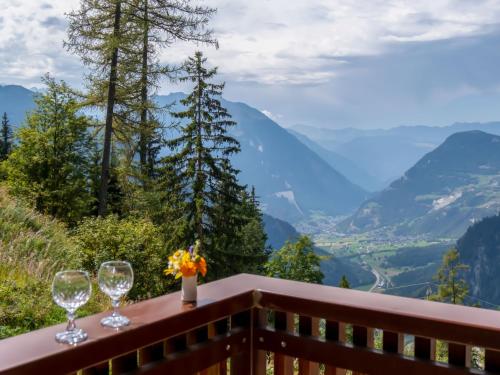 two wine glasses on a balcony with a view of mountains at Apartment Les Girolles A59 by Interhome in Verbier