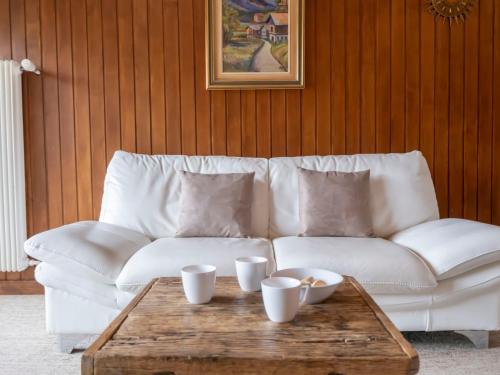 un sofá blanco sentado en una sala de estar con mesa de centro en Apartment Les Girolles A59 by Interhome, en Verbier