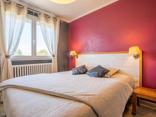 a bedroom with a large bed with a red wall at Holiday Home Ty Manolo by Interhome in Tregueux