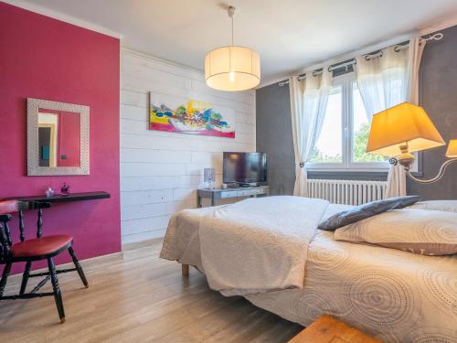 a bedroom with a bed and a table and a television at Holiday Home Ty Manolo by Interhome in Tregueux