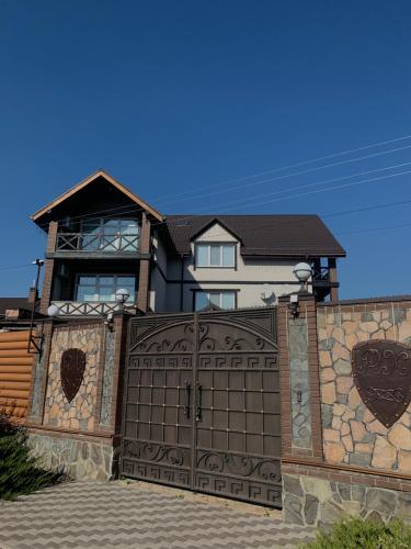una casa con un cancello di fronte a una recinzione di RELAX COMPLEX HOTEL a Boryspilʼ