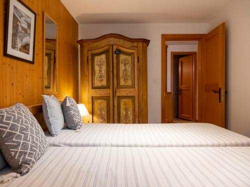two beds in a room with wooden walls at Apartment Baudrier A04 by Interhome in Verbier