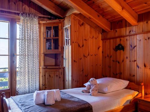 a teddy bear sitting on a bed in a room at Chalet Valet de Coeur by Interhome in Nendaz