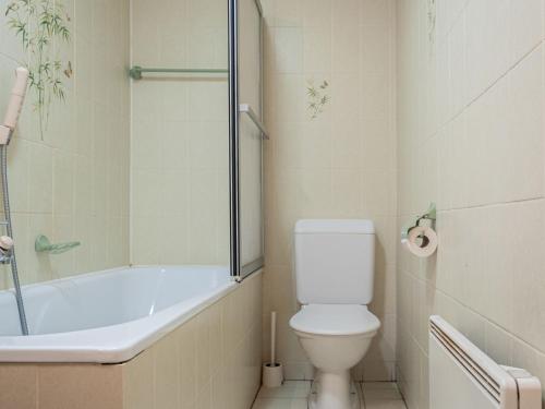a bathroom with a tub and a toilet and a shower at Chalet Valet de Coeur by Interhome in Nendaz