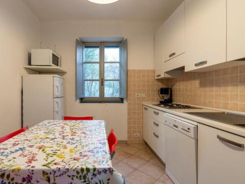 a kitchen with white cabinets and a table with a pattern at Apartment Canneto-3 by Interhome in Stellanello