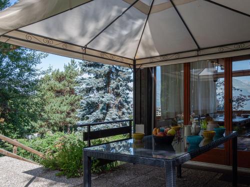 a screened in porch with a table on a patio at Chalet Valet de Coeur by Interhome in Nendaz